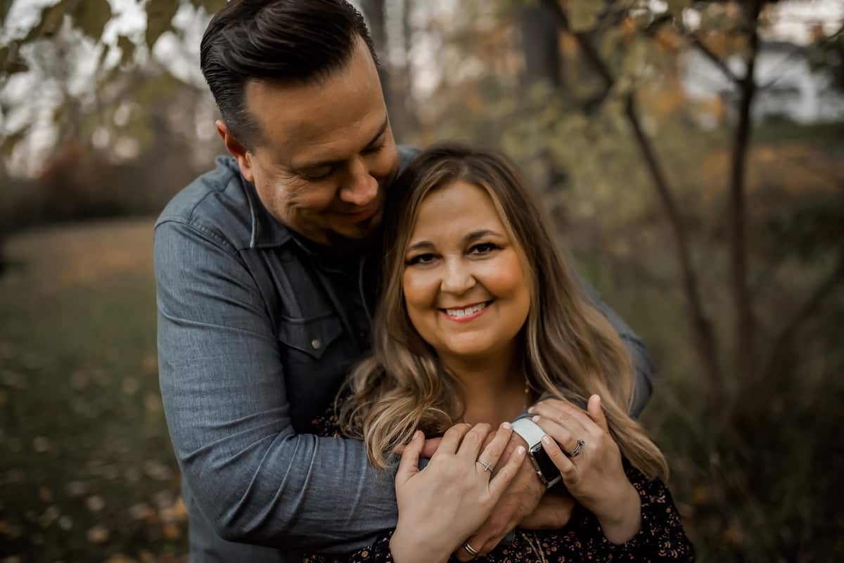 Cliff Johnson and his wife, Angela, embracing outdoors on an autumn day